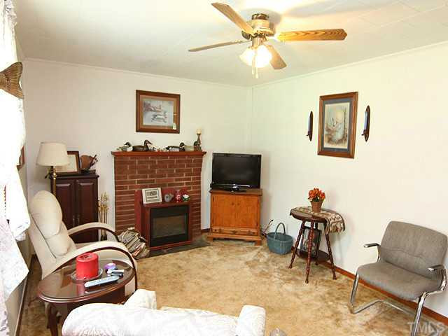 2135 Winkler Road Durham, NC 27712 - Photo 3 of 13 a living room with furniture a flat screen tv and a fireplace