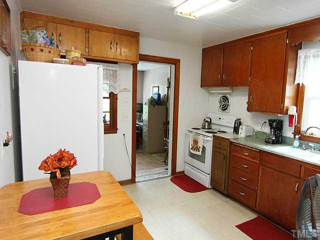 2135 Winkler Road Durham, NC 27712 - Photo 5 of 13 a kitchen with stainless steel appliances granite countertop a sink dishwasher a refrigerator and cabinets with wooden floor