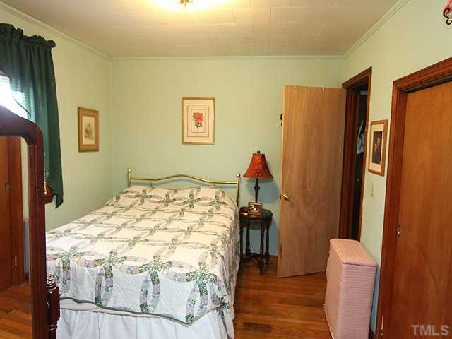 2135 Winkler Road Durham, NC 27712 - Photo 10 of 13 a bedroom with a bed and a wooden floor