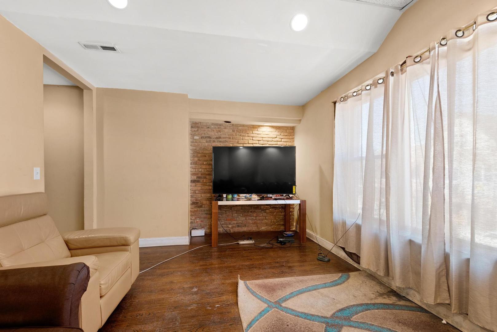 5941 West Chicago Avenue Chicago, IL 60651 - Photo 12 of 13 a living room with furniture and a flat screen tv