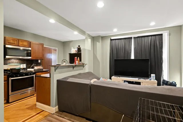 a kitchen with stainless steel appliances kitchen island granite countertop a stove and a microwave