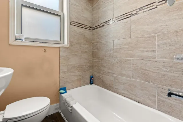 a white toilet sitting next to a bath tub and a shower