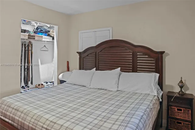 a bedroom with a bed and dresser with mirror
