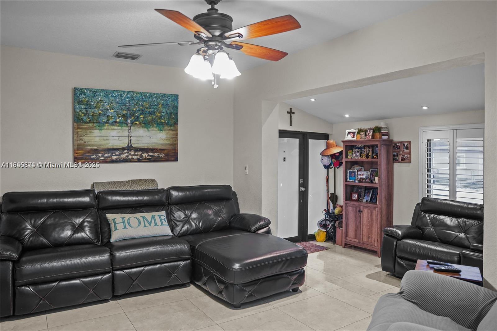117 West 34th Street Hialeah, FL 33012 - Photo 8 of 27 a living room with furniture a ceiling fan and a window