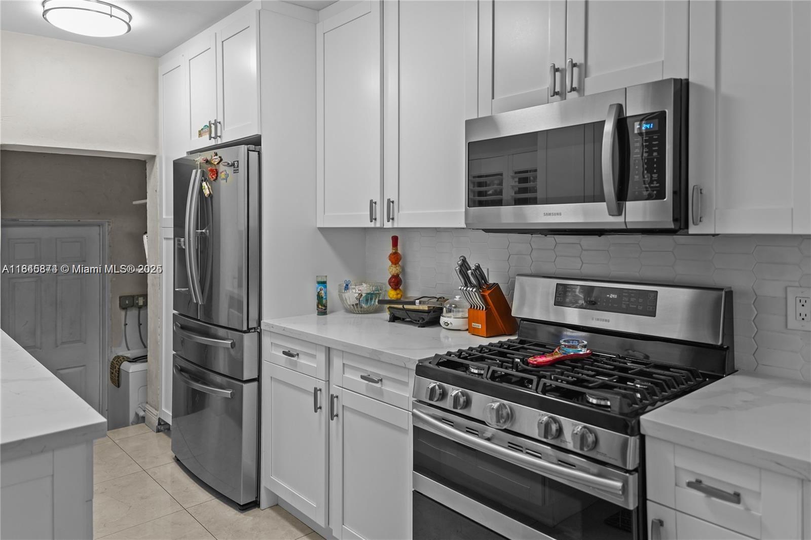 117 West 34th Street Hialeah, FL 33012 - Photo 10 of 27 a kitchen with stainless steel appliances and white cabinets