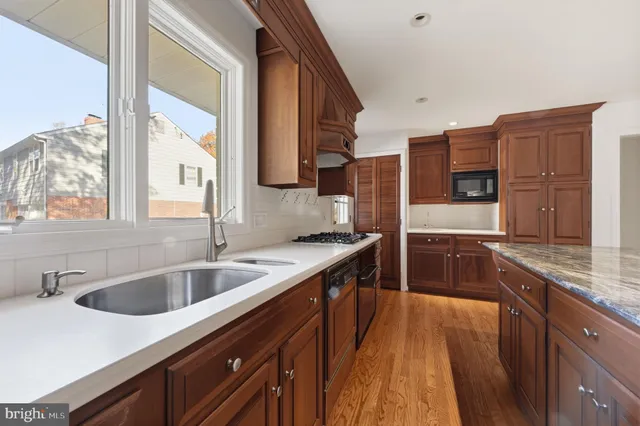 a kitchen with stainless steel appliances granite countertop a sink and a stove
