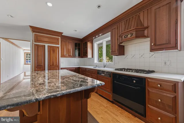 a kitchen with stainless steel appliances granite countertop a sink stove and cabinets