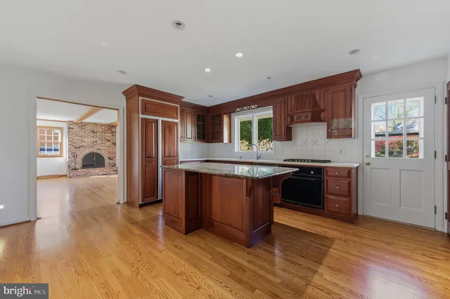 a kitchen with granite countertop cabinets stainless steel appliances and a wooden floor