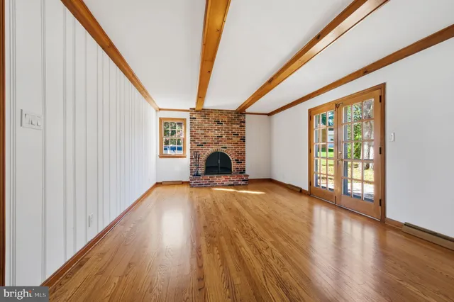 a view of empty room with wooden floor and fireplace