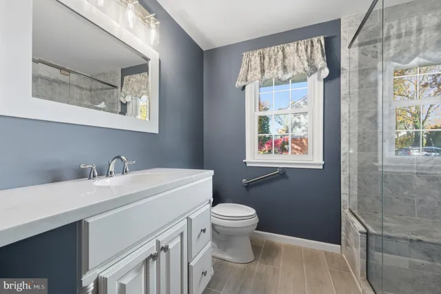 a bathroom with a sink a toilet and a window