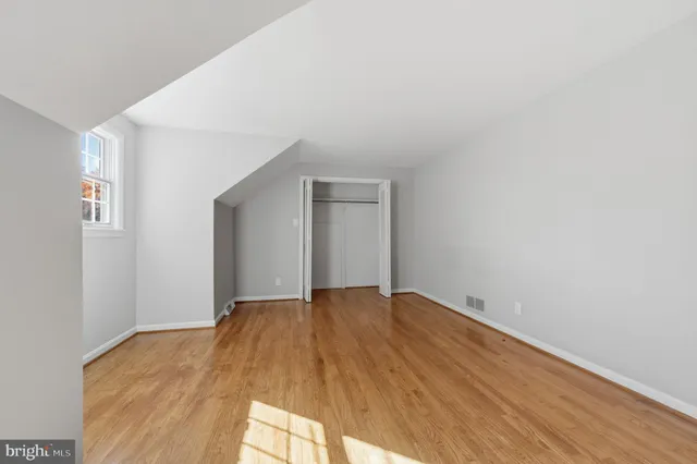 a view of an empty room and wooden floor