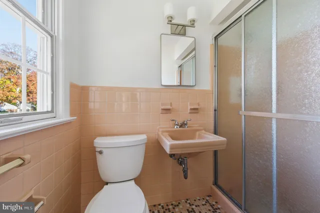 a bathroom with a toilet sink and mirror