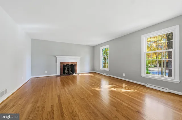 wooden floor fireplace and windows in an empty room