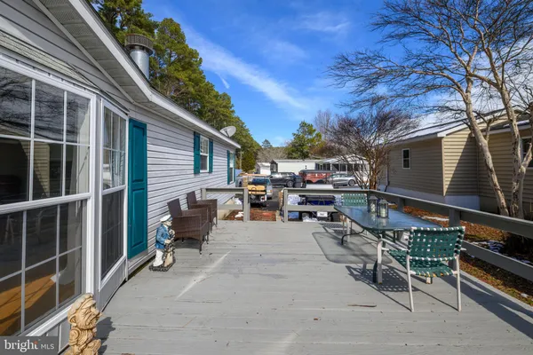 a view of a patio with table and chairs and potted plants with wooden floor and fence