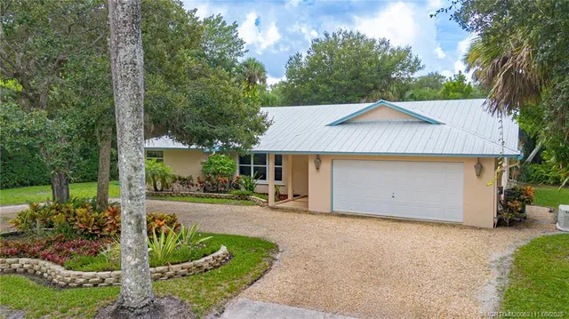 a front view of a house with a garden and plants