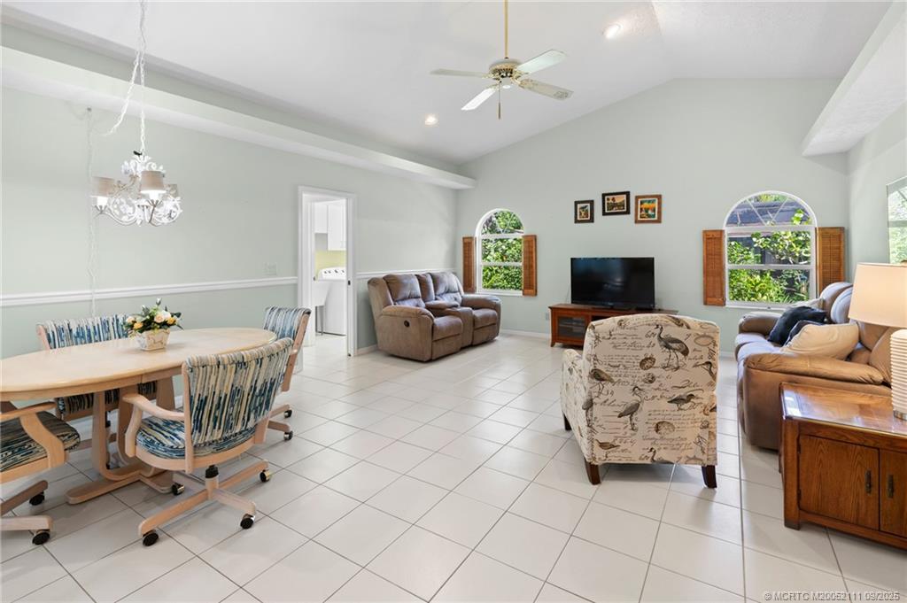 3418 Southeast Jamaica Way Stuart, FL 34997 - Photo 16 of 35 a living room with furniture a fireplace and a chandelier