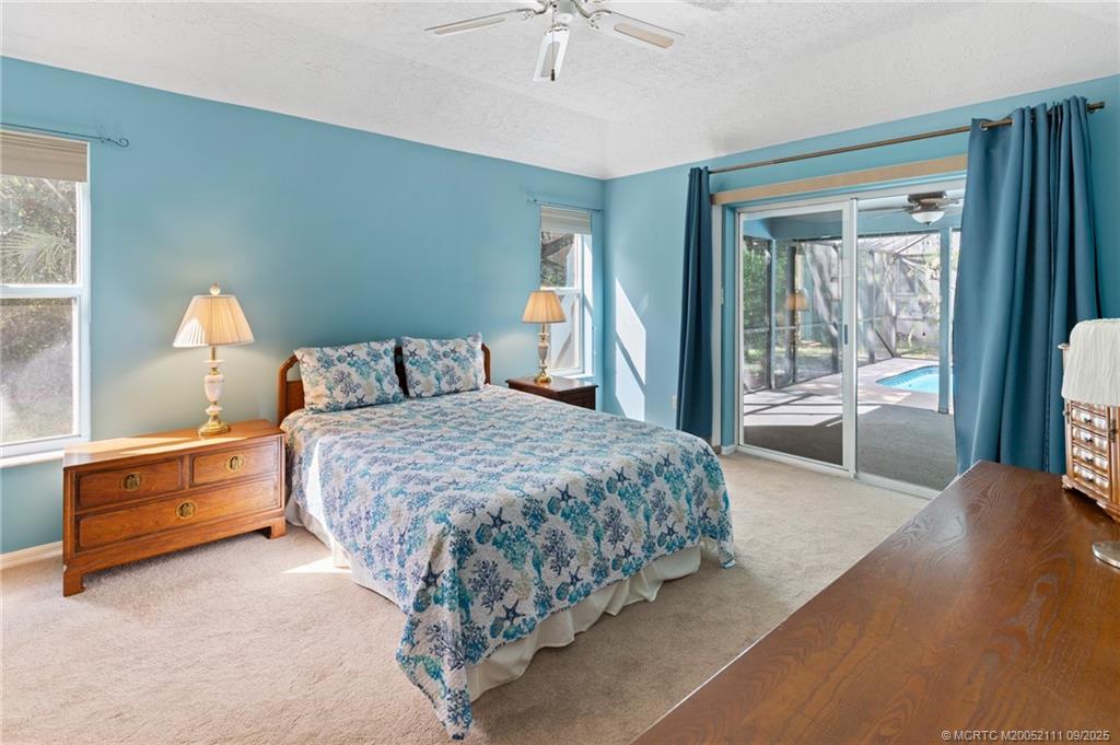 3418 Southeast Jamaica Way Stuart, FL 34997 - Photo 19 of 35 a bedroom with a large bed and a chandelier