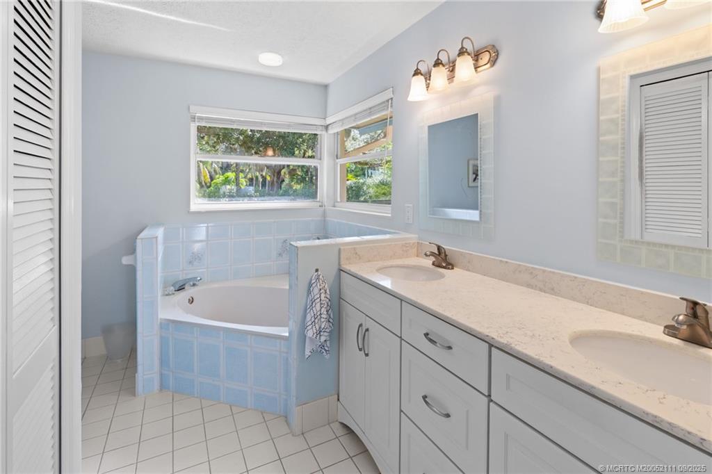 3418 Southeast Jamaica Way Stuart, FL 34997 - Photo 21 of 35 a bathroom with a tub a sink and mirror