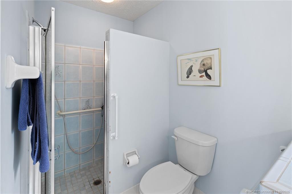 3418 Southeast Jamaica Way Stuart, FL 34997 - Photo 24 of 35 a white toilet sitting next to a bathroom sink and vanity