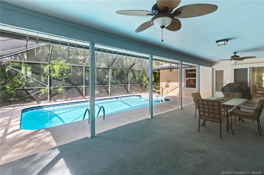 3418 Southeast Jamaica Way Stuart, FL 34997 - Photo 29 of 35 a living room with furniture and a floor to ceiling window