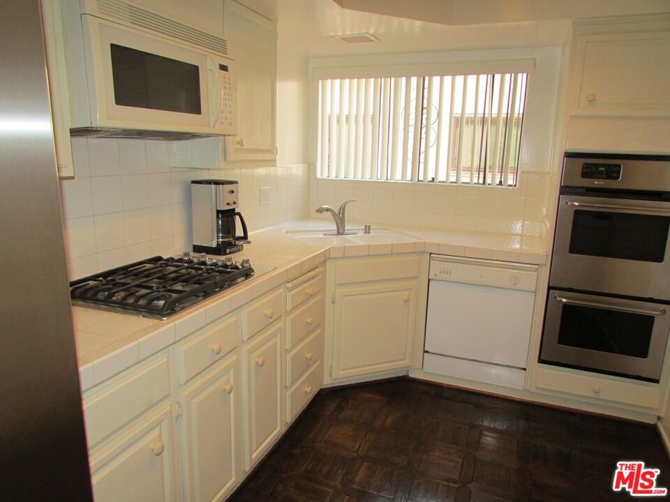 1850 Midvale Avenue, Unit 7 Los Angeles, CA 90025 - Photo 12 of 13 a kitchen with white cabinets and appliances