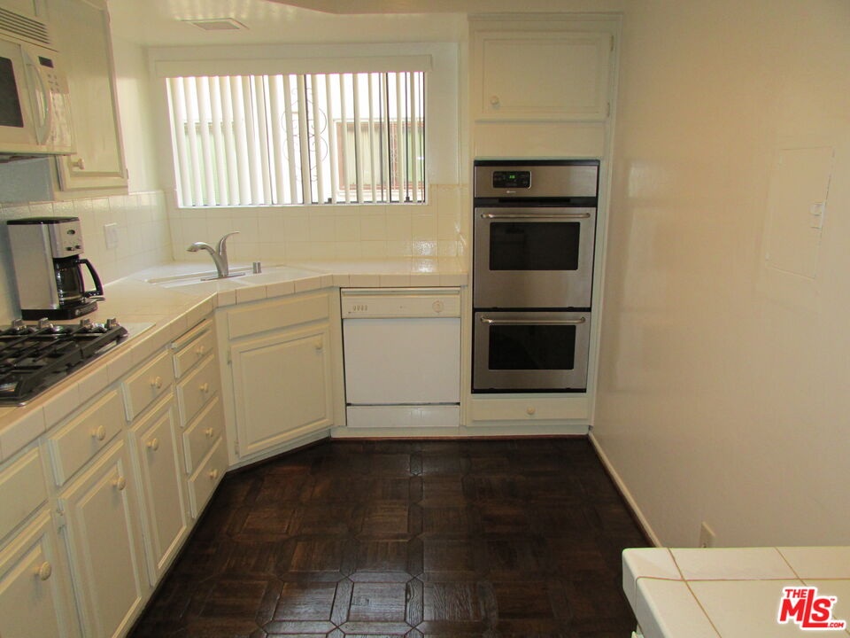 1850 Midvale Avenue, Unit 7 Los Angeles, CA 90025 - Photo 13 of 13 a kitchen with granite countertop white cabinets and a stove