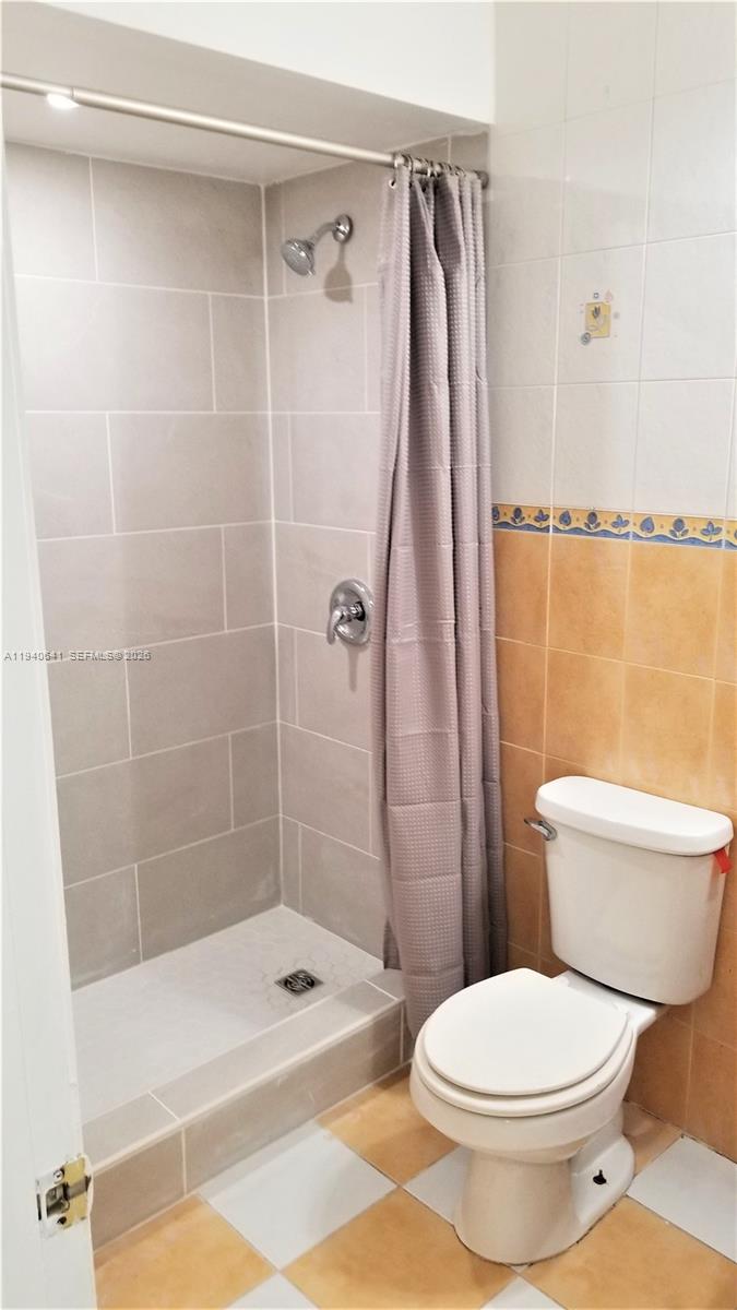 9723 Southwest 138th Avenue, Unit IA2L Miami, FL 33186 - Photo 14 of 27 a bathroom with a toilet and shower