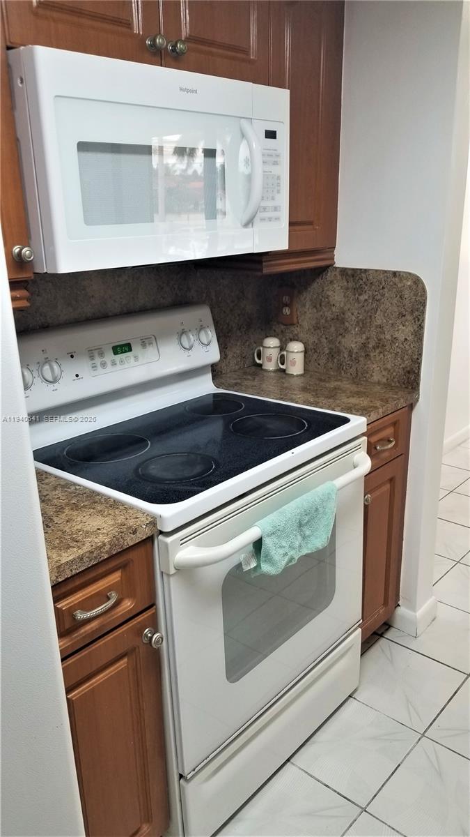 9723 Southwest 138th Avenue, Unit IA2L Miami, FL 33186 - Photo 18 of 27 a stove top oven sitting inside of a kitchen