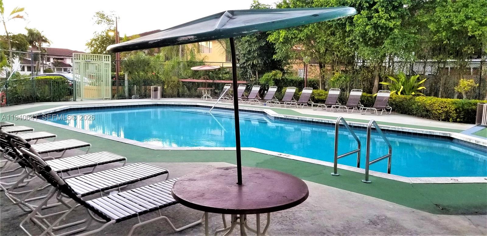 9723 Southwest 138th Avenue, Unit IA2L Miami, FL 33186 - Photo 26 of 27 a swimming pool with outdoor seating and yard