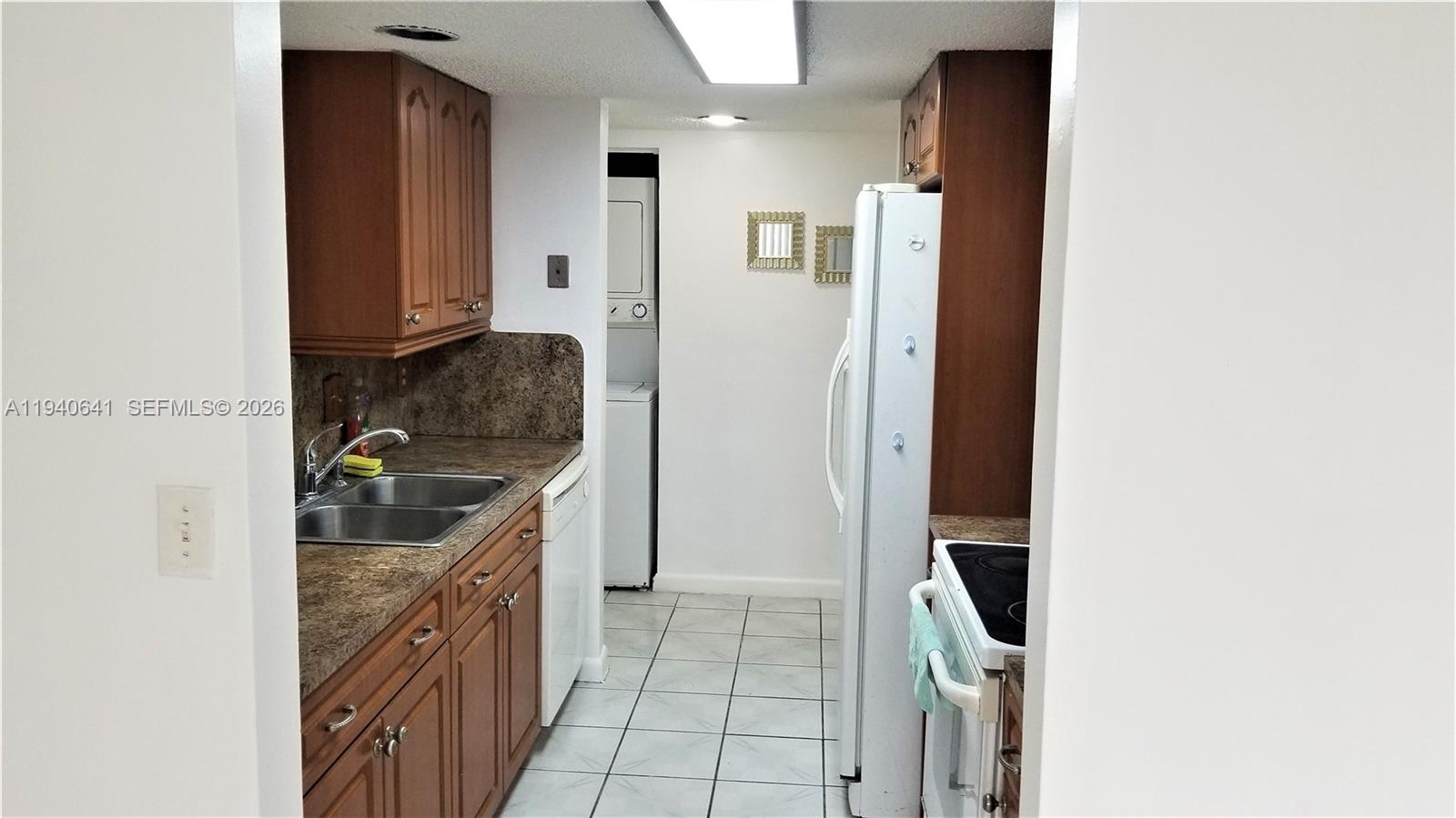 9723 Southwest 138th Avenue, Unit IA2L Miami, FL 33186 - Photo 3 of 27 a kitchen with a refrigerator and a sink