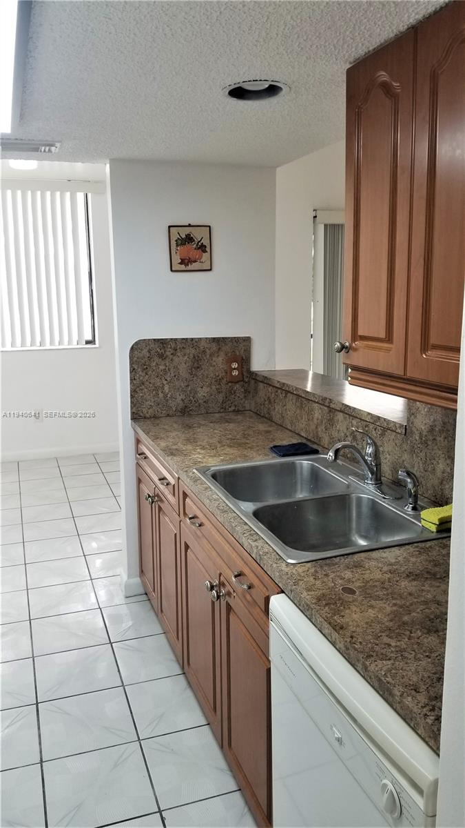 9723 Southwest 138th Avenue, Unit IA2L Miami, FL 33186 - Photo 6 of 27 a kitchen with a sink stove and cabinets
