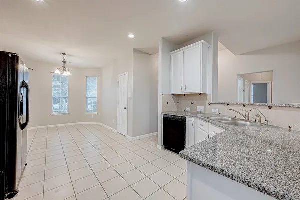 a large kitchen with kitchen island granite countertop a sink cabinets and stainless steel appliances