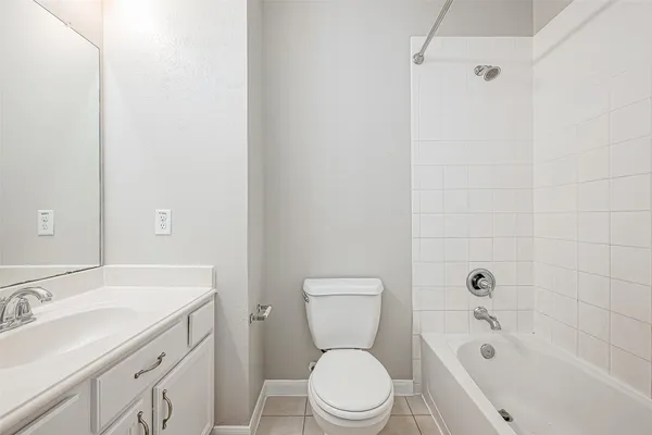 a bathroom with a bathtub shower sink mirror and toilet