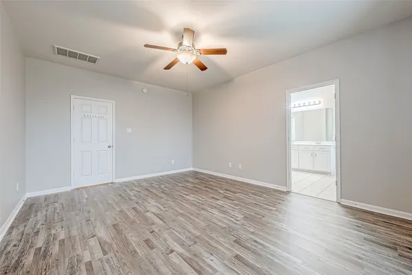 a view of an empty room with wooden floor
