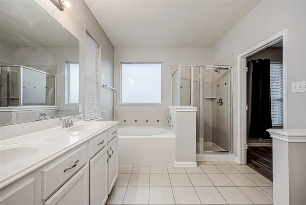 a spacious bathroom with a bathtub sink and mirror