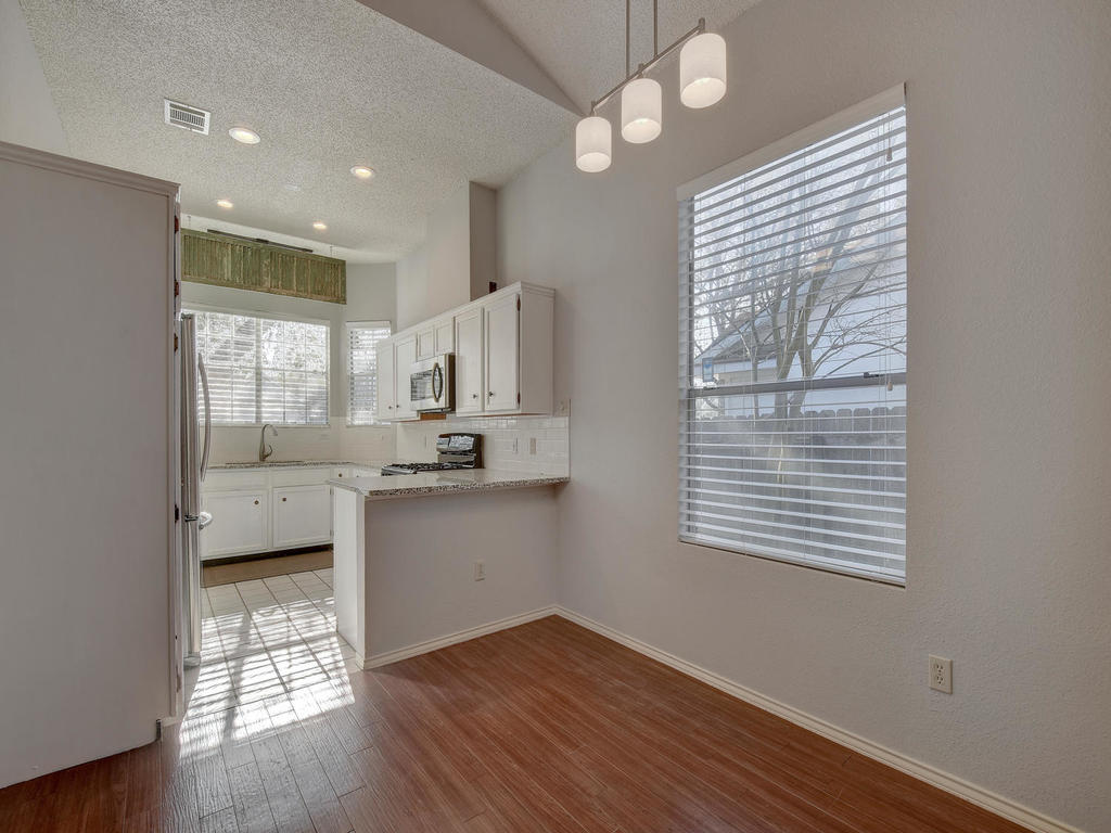 3019 Rochelle Drive Austin, TX 78748 - Photo 8 of 21 a kitchen with cabinets wooden floor and a large window