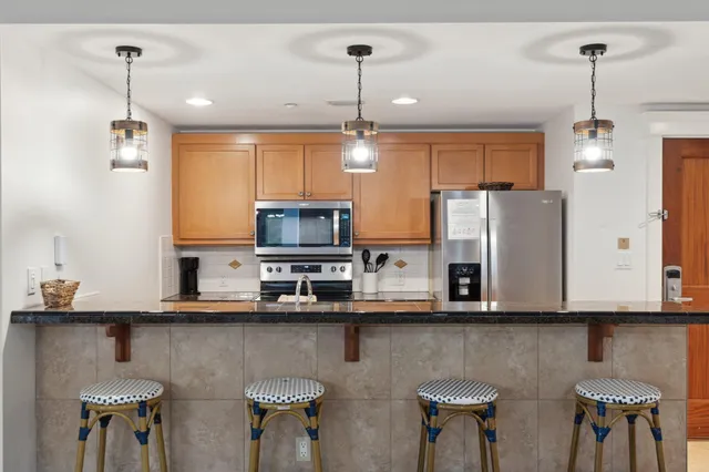 a kitchen with stainless steel appliances granite countertop a refrigerator stove and microwave