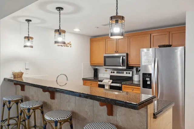 a kitchen with stainless steel appliances granite countertop a sink a stove and a refrigerator