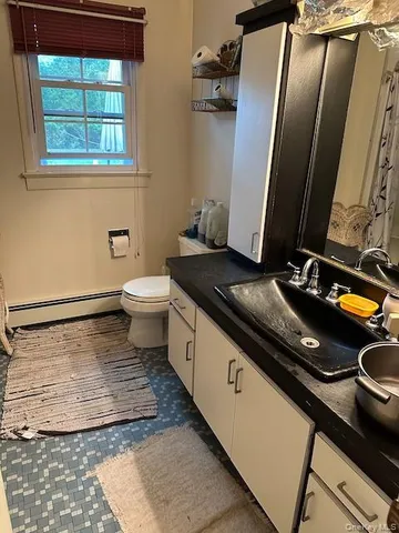 a bathroom with a granite countertop sink and a mirror