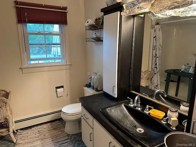 a bathroom with a granite countertop sink a toilet and a mirror