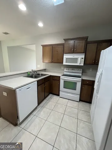 a kitchen with a stove sink and cabinets