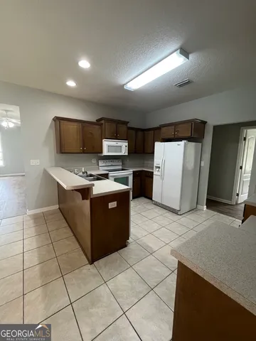 a kitchen with a sink a refrigerator and a stove top oven