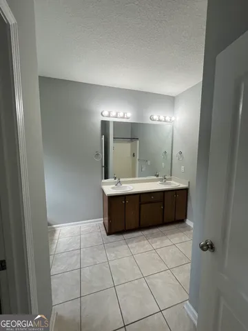 a bathroom with a tub a sink a mirror and a shower