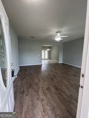 an empty room with wooden floor and mirror