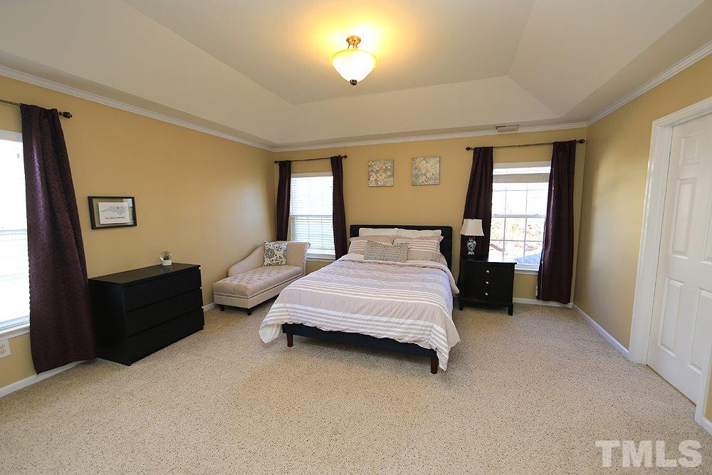 800 Roni Court Cary, NC 27519 - Photo 14 of 25 a spacious bedroom with a bed and a lamp