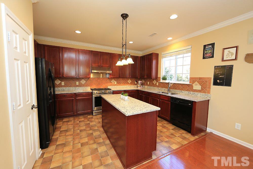 800 Roni Court Cary, NC 27519 - Photo 9 of 25 a kitchen with a refrigerator a sink dishwasher with a dining table and chairs