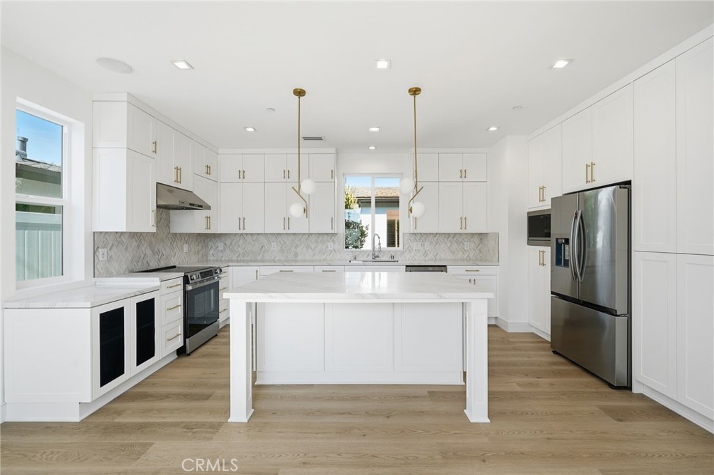 317 Rochester Street, Unit B Costa Mesa, CA 92627 - Photo 3 of 12 a kitchen with kitchen island a sink stainless steel appliances and cabinets