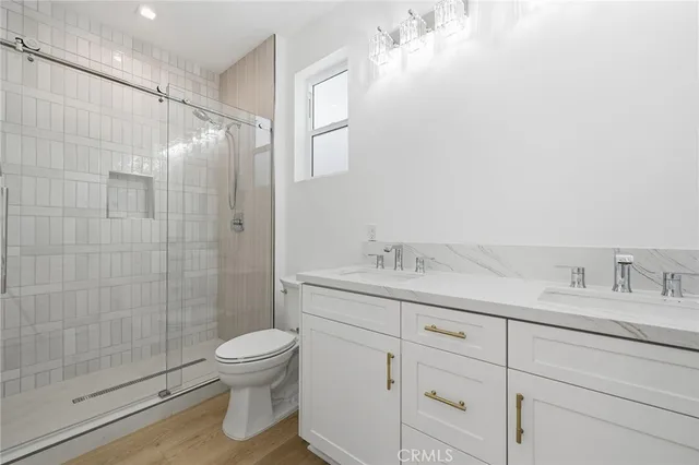 a bathroom with a granite countertop sink a toilet and a shower