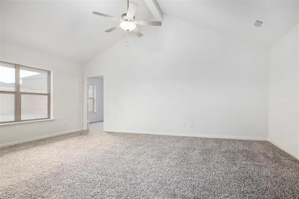 an empty room with windows and fan