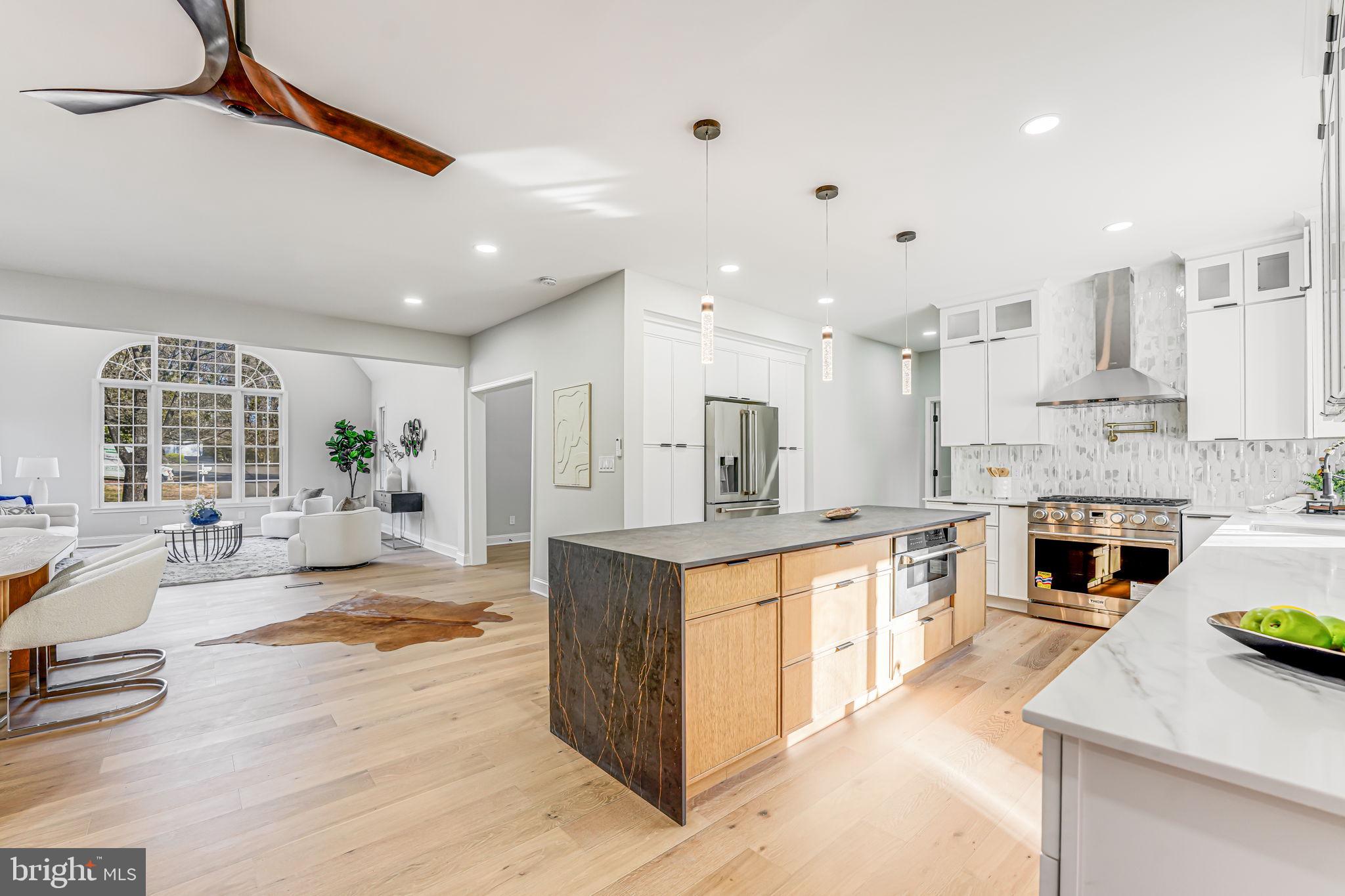 3620 Hill Street Fairfax, VA 22030 - Photo 19 of 71 a large white kitchen with a stove a sink a refrigerator and a dining table with wooden floor